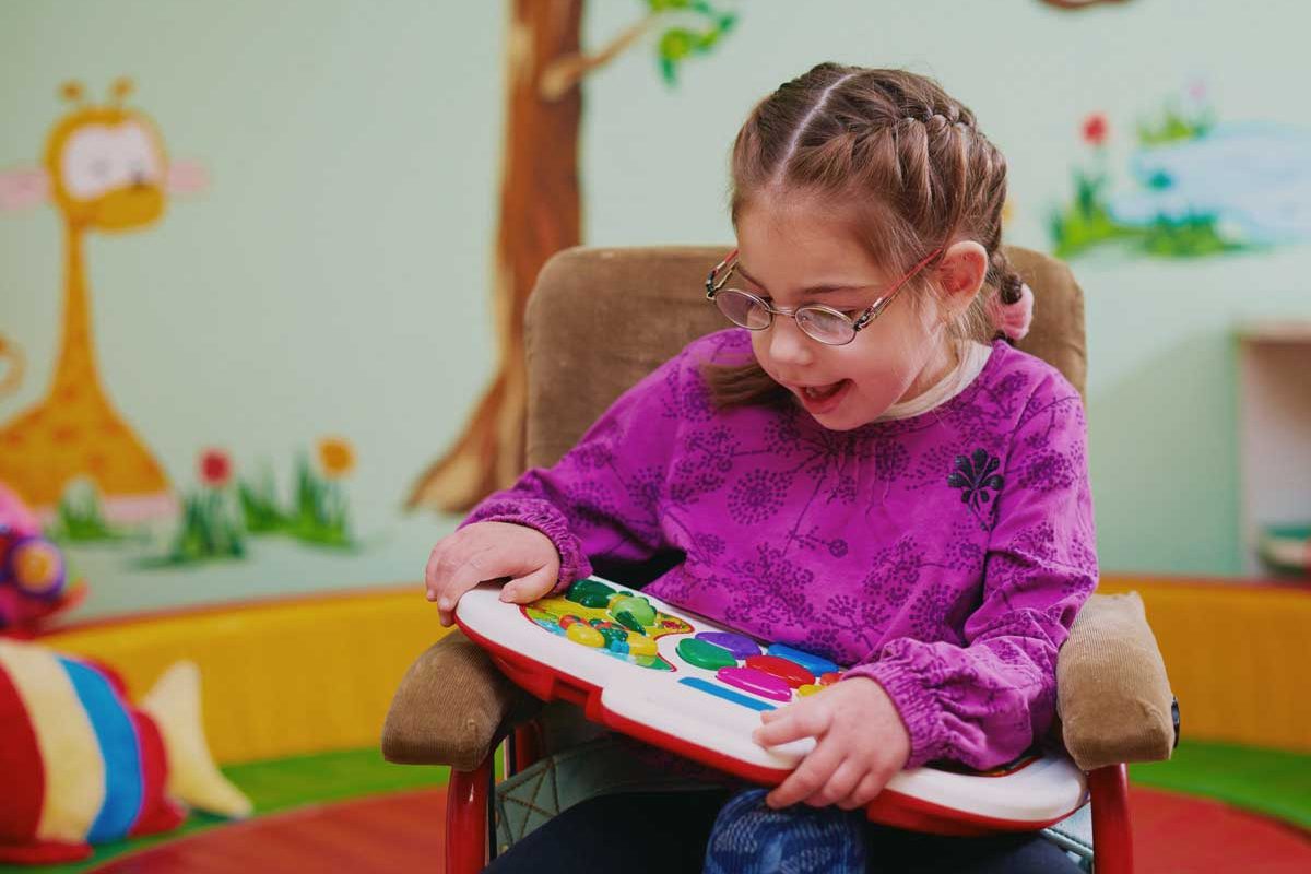 Girl in wheelchair playing with toy